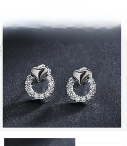 Détail des boucles d'oreilles cœur en argent avec cercle serti de zircons cubiques