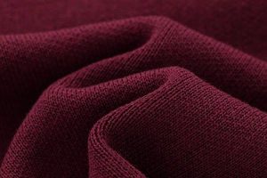 Macro shot of dark red fine knit fabric showing soft texture and detailed weave