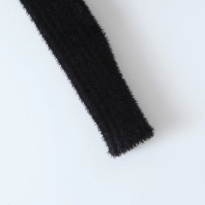 Detailed macro view of black faux fur texture on a V-neck knitted long sleeve top
