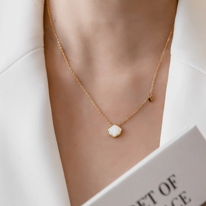 Elegant gold sea shell necklace for women featuring a small heart charm and white pearl accent