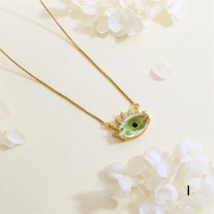 Detail of gold plated evil eye necklace with green crystal and zircon stones
