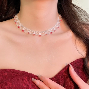 Detailed close-up of a handmade beaded choker with white crystals and red accents