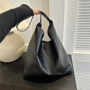 Minimalist black leather tote bag for women, large capacity shoulder bag shown held by hand