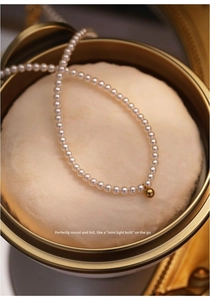 Close-up of natural freshwater pearl necklace with 14K gold bead in a vintage gift box