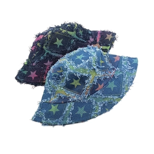 Distressed denim bucket hat with frayed star patches in dark and light blue wash