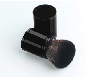 Detail of retractable makeup brush with dense gradient bristles and black glossy casing