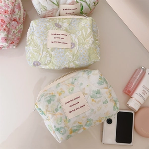 Detailed view of quilted cotton makeup bags with green and pink floral patterns