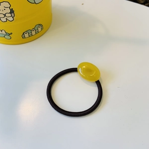Minimalist elastic hair tie with a smooth translucent yellow oval resin accessory