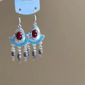 Böhmische Silberohrringe mit rotem Stein und blau-weißen Perlenquasten auf Displaykarte