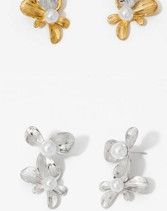 Detail of floral earrings in gold and silver finish with textured metal and white pearls