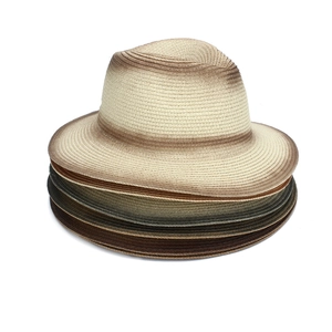 Detailed stack of multi-color ombre woven fedora straw hats showing breathable textures