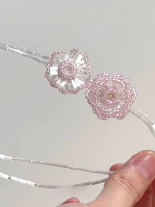 Detail of handmade beaded flower pendant with pink petals and white glass tubes