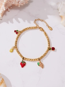 Detail of gold-plated stainless steel bracelet with colorful fruit charms and zircons