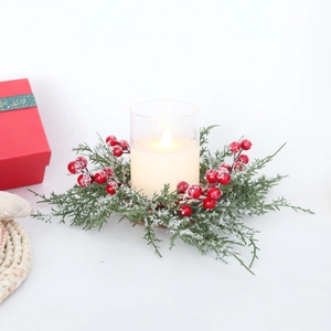 Christmas candle ring with frosted pine needles, red berries and glass votive holder