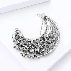 Detailed back view of silver crescent moon brooch with pin clasp and yellow rhinestones