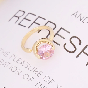 Close-up of a round pink zircon stone in a modern gold-plated adjustable ring setting