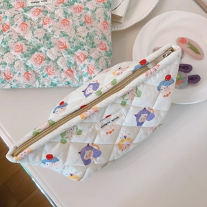 Detailed view of floral and cartoon quilted cotton cosmetic bags with zip closure