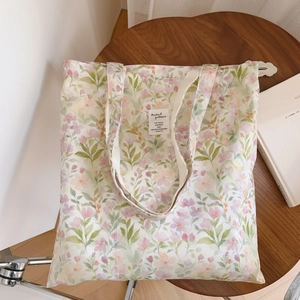 Détail du motif floral à l'aquarelle et étiquette en tissu sur le sac en coton