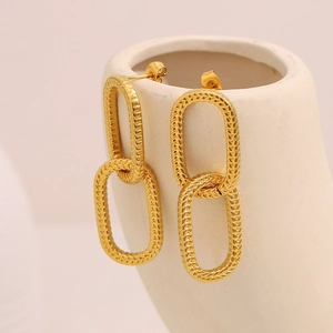Dettaglio macro di orecchini a doppio cerchio placcati oro 18K con trama a pelle di serpente