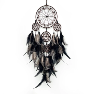 Handmade dream catcher with brown woven rings and black feathers for wall decoration