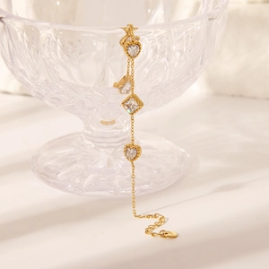 Macro shot of 18K gold plated S925 heart and square zircon charms on a delicate chain