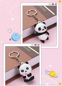 Detail süßer Panda-Schlüsselanhänger mit winkendem Herz-Design und rosa Handy-Zubehör