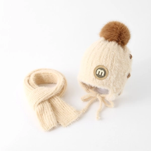 Detaillierte Textur des Baby-Wintersets mit M-Etikett und großem Kunstpelz-Pompon