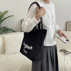 Detail of black canvas tote bag with Bonjour magic print and leopard faux fur lining