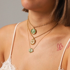Three-layer gold stainless steel necklace with green and pearl starfish pendants on a model