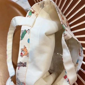 Detail of red polka dot and puppy pattern on canvas tote with reinforced stitching