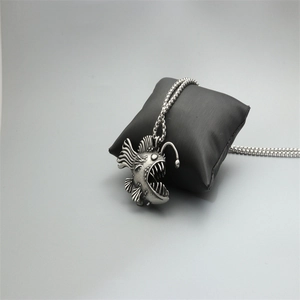 Retro stainless steel anglerfish pendant necklace for men on a black jewelry pillow