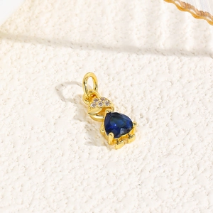 Macro shot of 18k gold turtle pendant featuring a heart-shaped blue gem and tiny diamonds