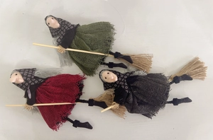 Three Halloween witch dolls on brooms with green, red, and black fabric outfits