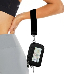 Detail of a black wrist pouch with clear ID window and zipper on a model's arm
