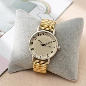 Fashionable women's gold quartz watch with artistic numerals and cream-colored dial