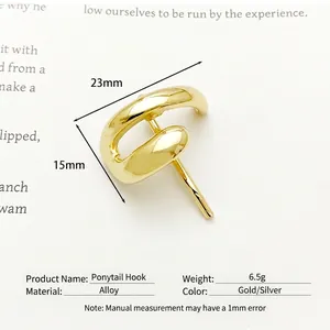 Eleganter goldener Haargummi-Haken aus Legierung mit poliertem Finish auf einem Buch