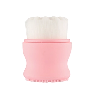 Detail of pink silicone facial brush with soft white bristles and massaging base