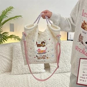 Detailed close-up of quilted tote bag with cute cartoon cat embroidery and soft texture