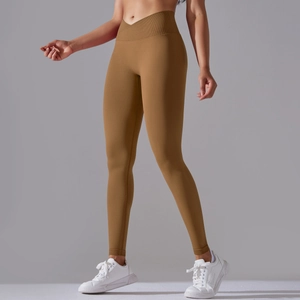 Detail of cross-waist design and peach butt lifting effect on brown yoga leggings