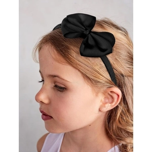 Close-up of a young girl wearing a black ribbed bow headband with fine fabric texture