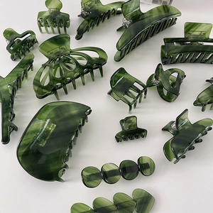 Green twill acetate claw clip with marble pattern for hair styling shown on white surface