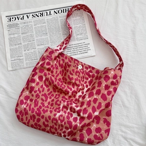 Detail of pink leopard canvas tote bag with magnetic snap closure on white fabric