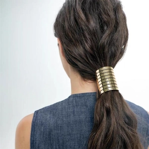 Minimalist gold metal hair cuff with horizontal stripes for sleek low pony styles