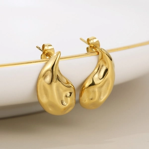 Macro detail of 18K gold stainless steel teardrop earrings with a liquid lava texture