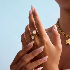 Close-up of adjustable 18K gold plated ring with two round moonstones on model hand
