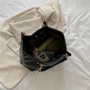 Grand sac cabas noir avec intérieur spacieux contenant un parapluie et des objets quotidiens