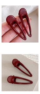 Detail of burgundy geometric hollow hairpin with glossy finish and crocodile clip design