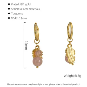 Detailed view of 18K gold plated stainless steel feather earrings with turquoise beads
