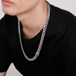 Close-up of a men's chunky silver stainless steel Cuban link chain necklace on model