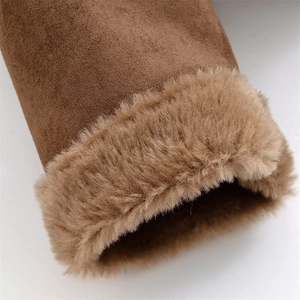 Dettaglio del bordo in finta pelliccia e camoscio sul polsino di un cappotto marrone